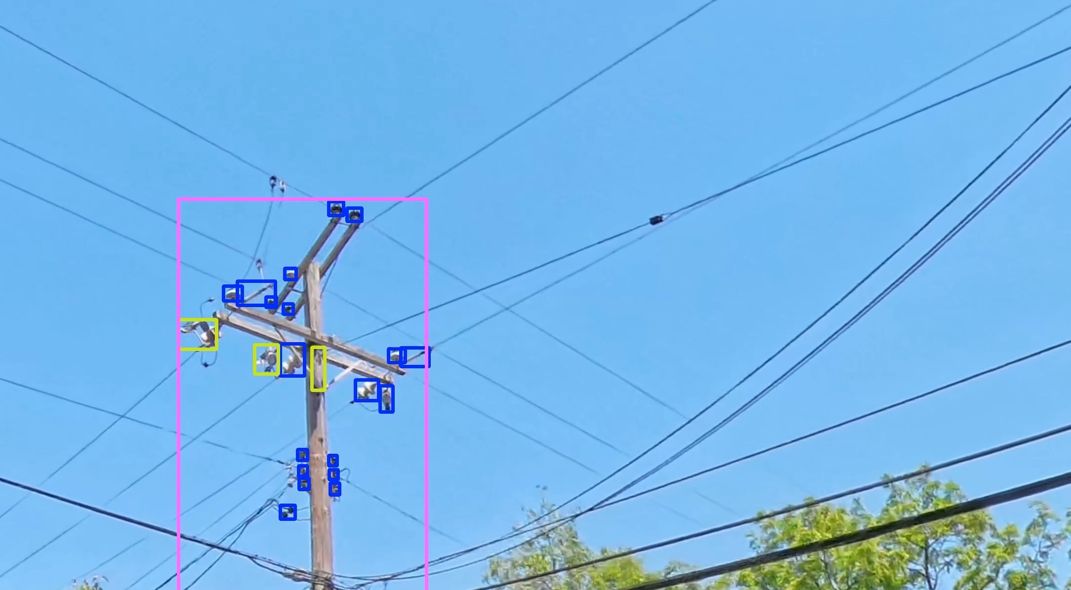 Image of wood utility pole with blue, yellow, purple boxes indicating pole components. Trees and sky are in the background.